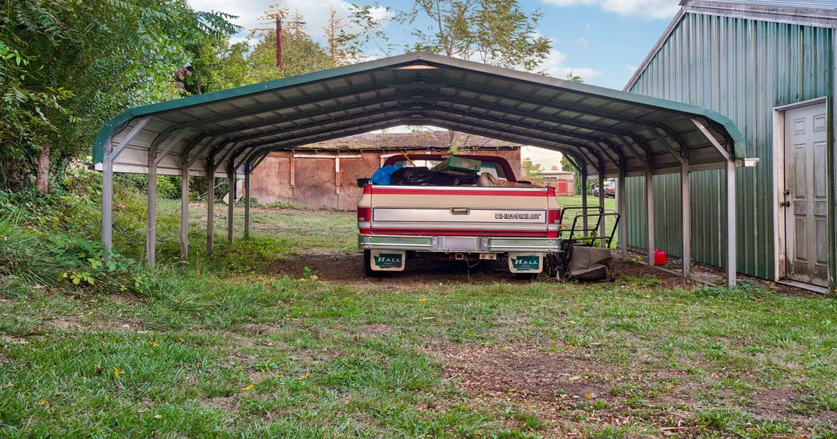 Camionnette stationnée sous un abri d'auto permanent en métal