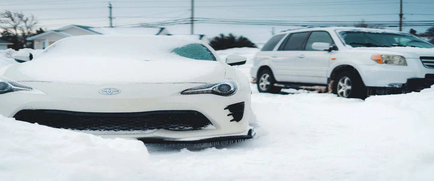 Voitures enneigées dans une entrée en hiver au Québec